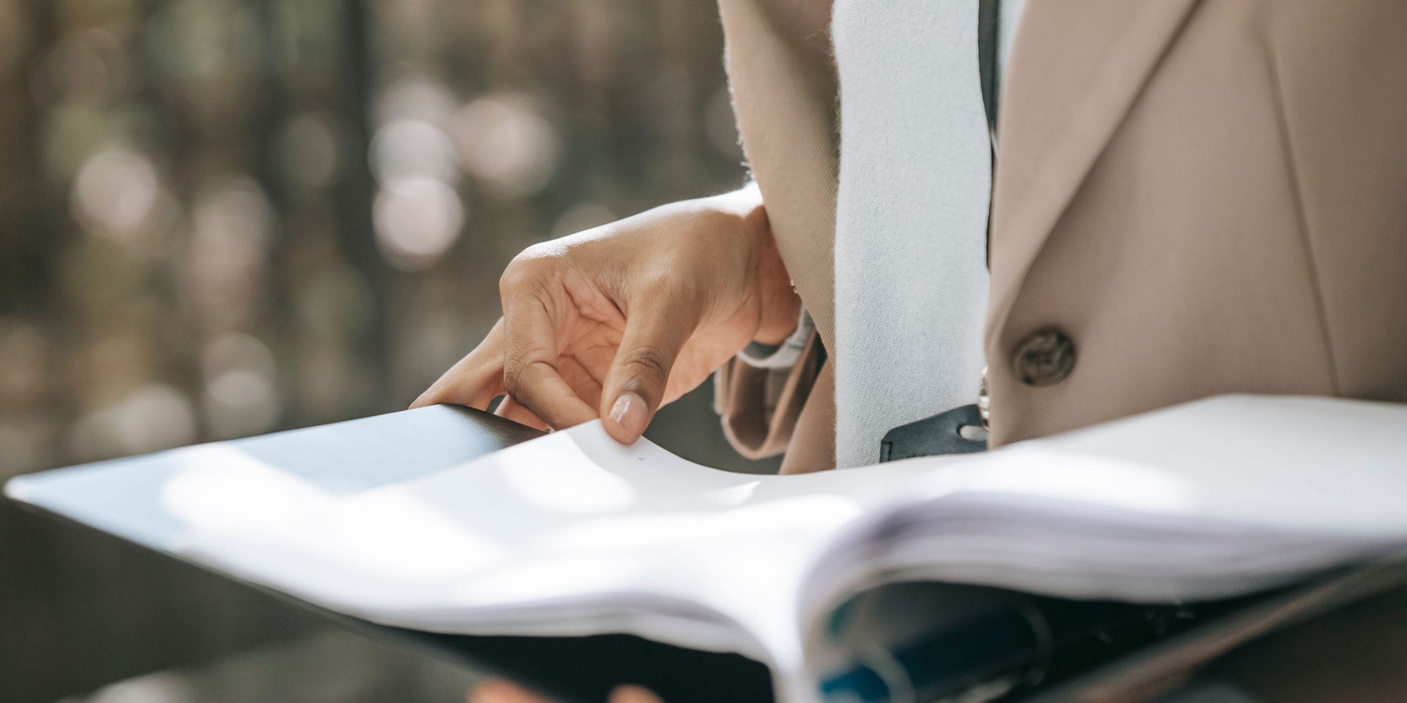 Lawyer turning a page in an open binder of corporate records